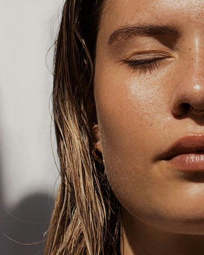 Close-up of a person's face with wet hair, sunlit skin
