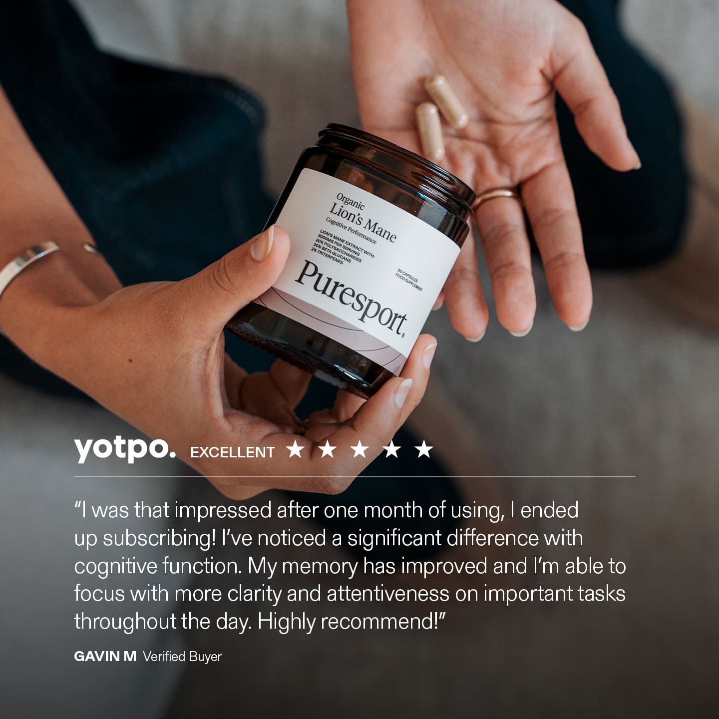 Person holding a jar of Lion's Mane supplements by Puresport' with a Yotpo review on a blurred background.