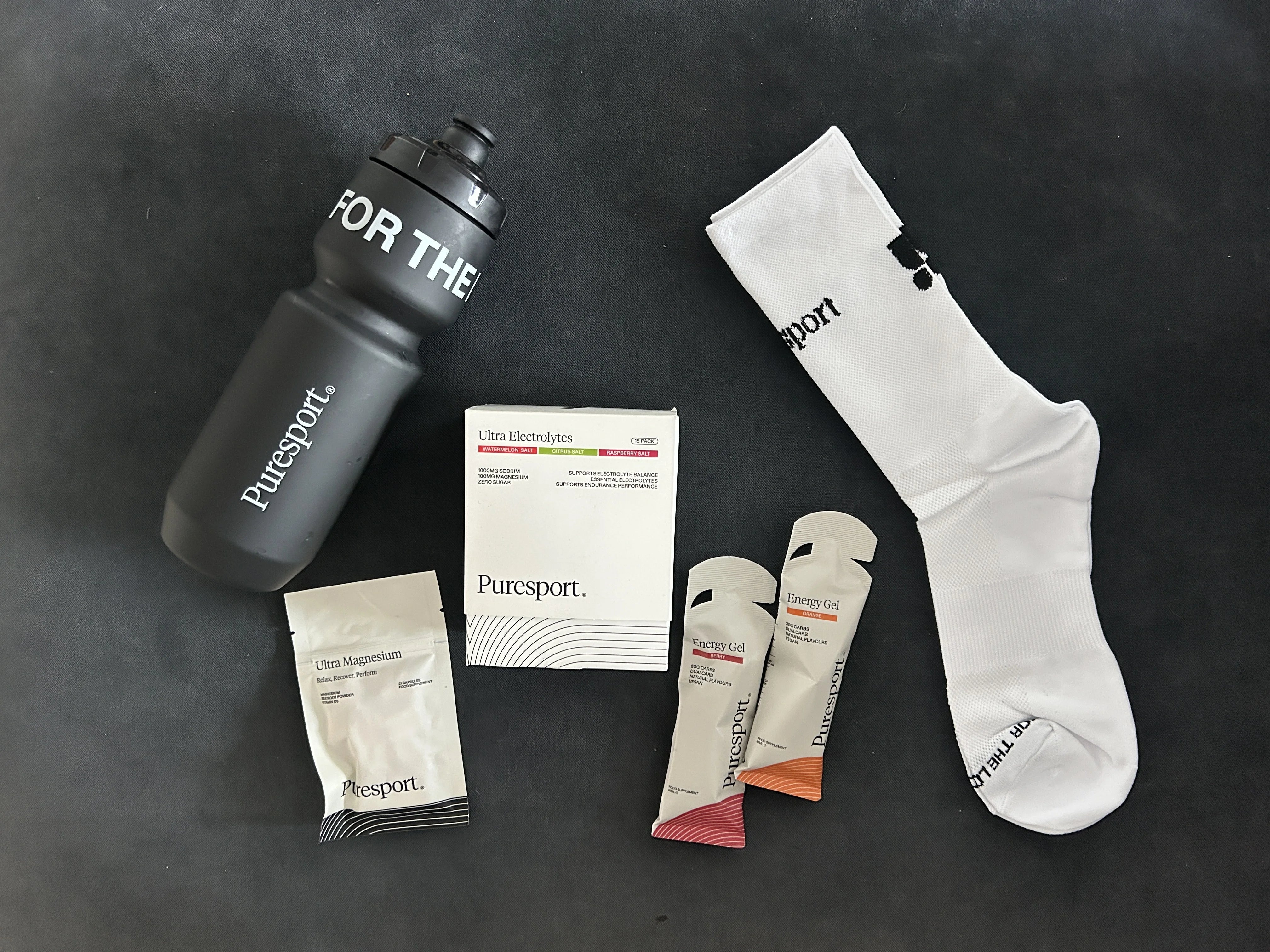 Runner packing crate flat-lay with Puresport electrolytes, bottle, socks and running gear