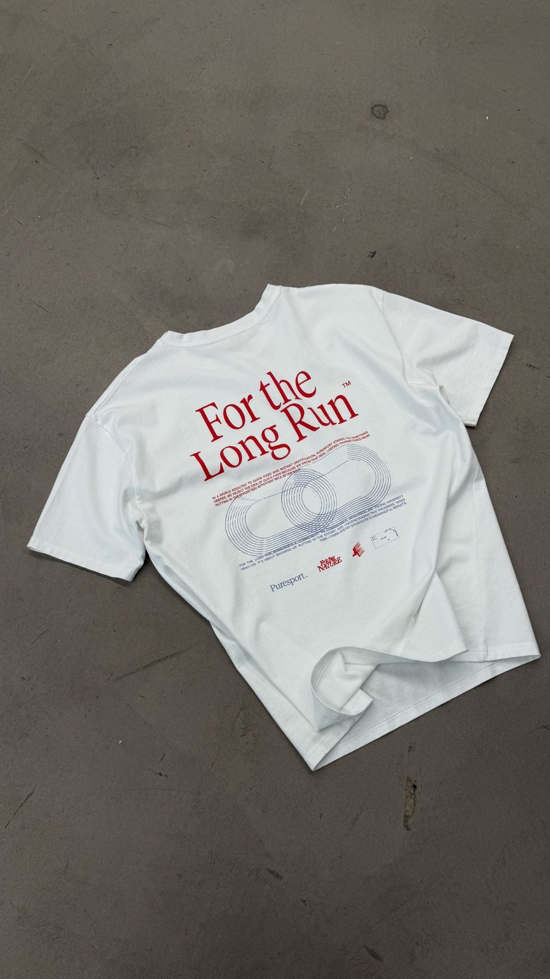 White cotton t-shirt with 'For the Long Run' text on a grey surface