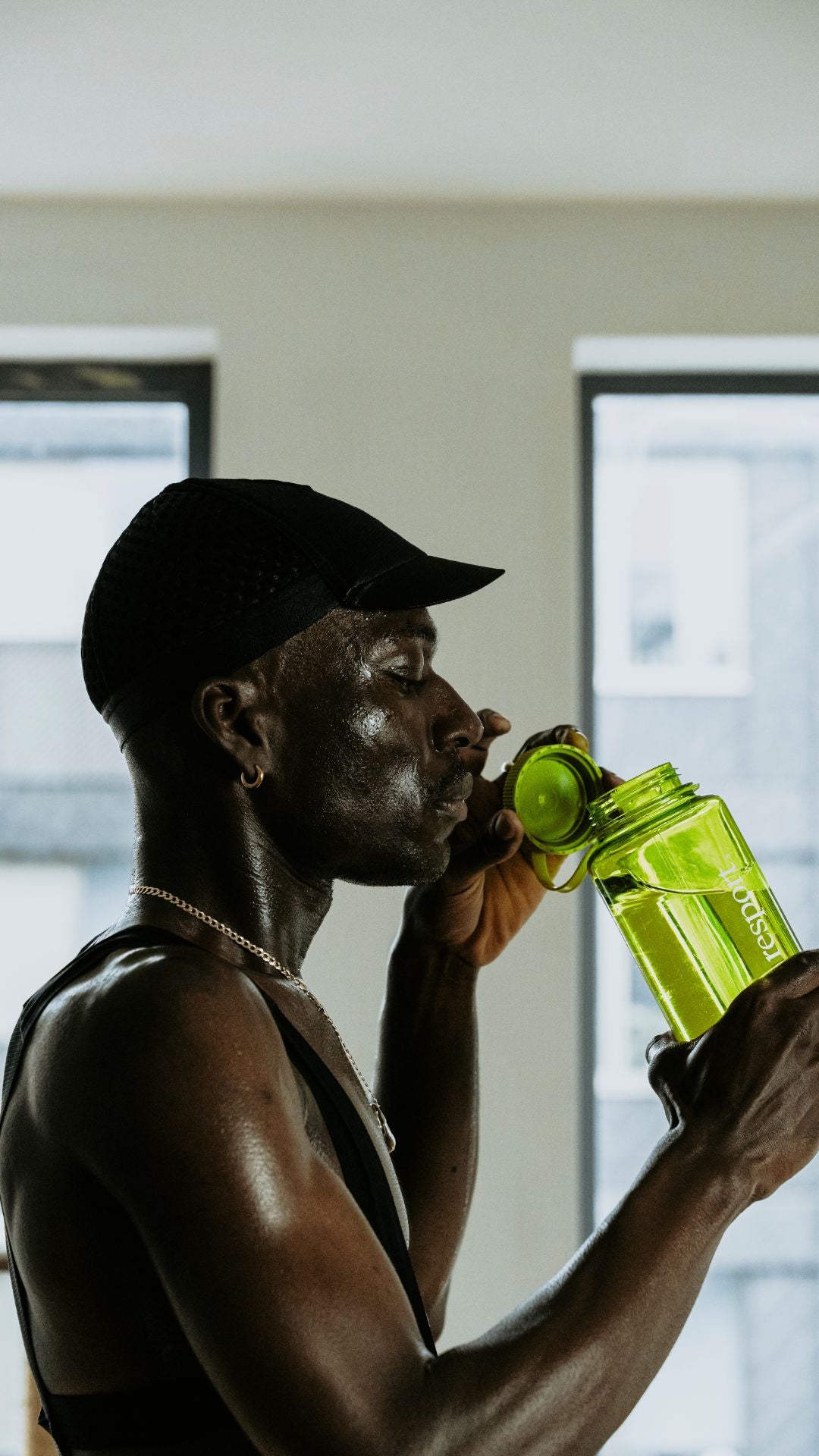 Cyclist drinking from a green bottle nalgene bottle. 