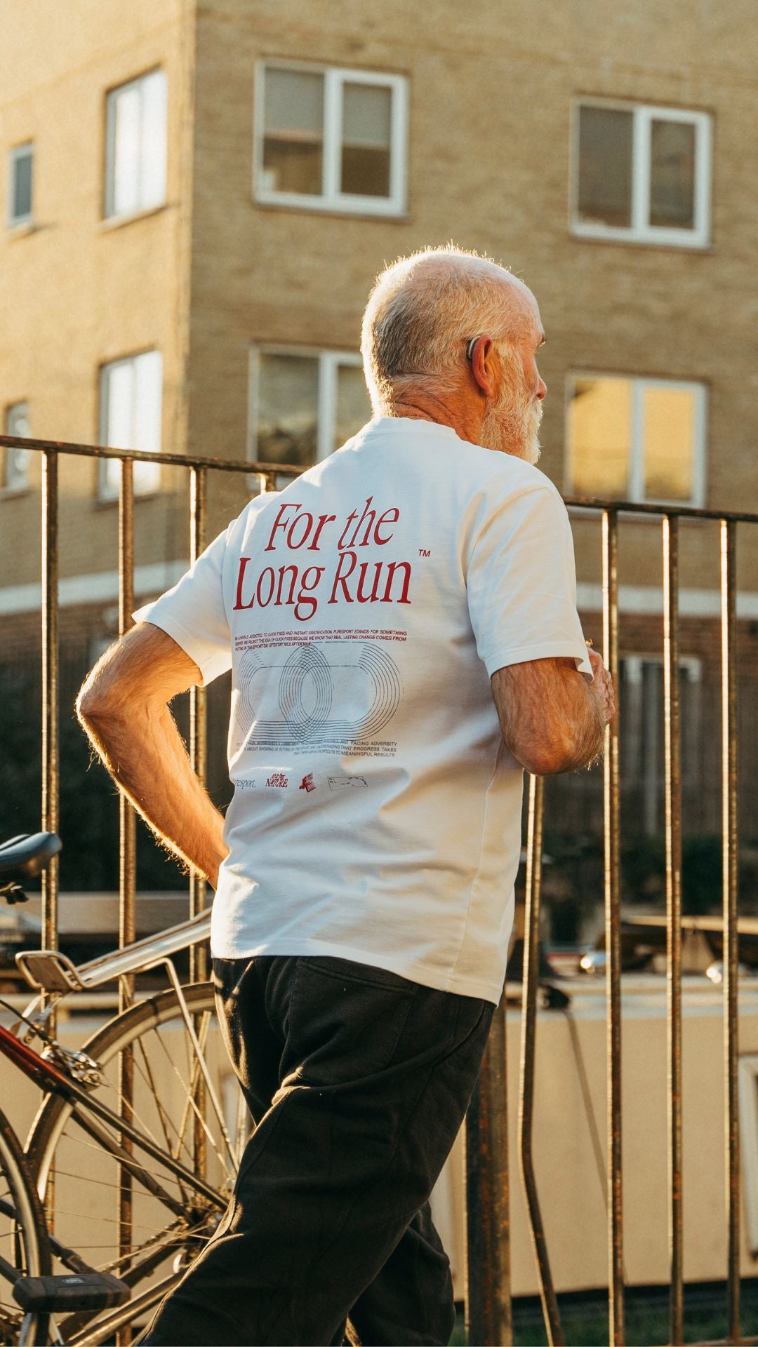 Man wearing a white t-shirt by Puresport with For the Long Run text on the canal. 