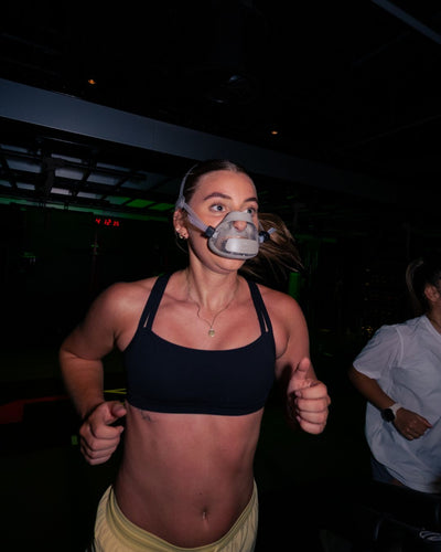 Person running while wearing a mask for exogenous carbohydrate oxidation rates for carbohydrates testing. 