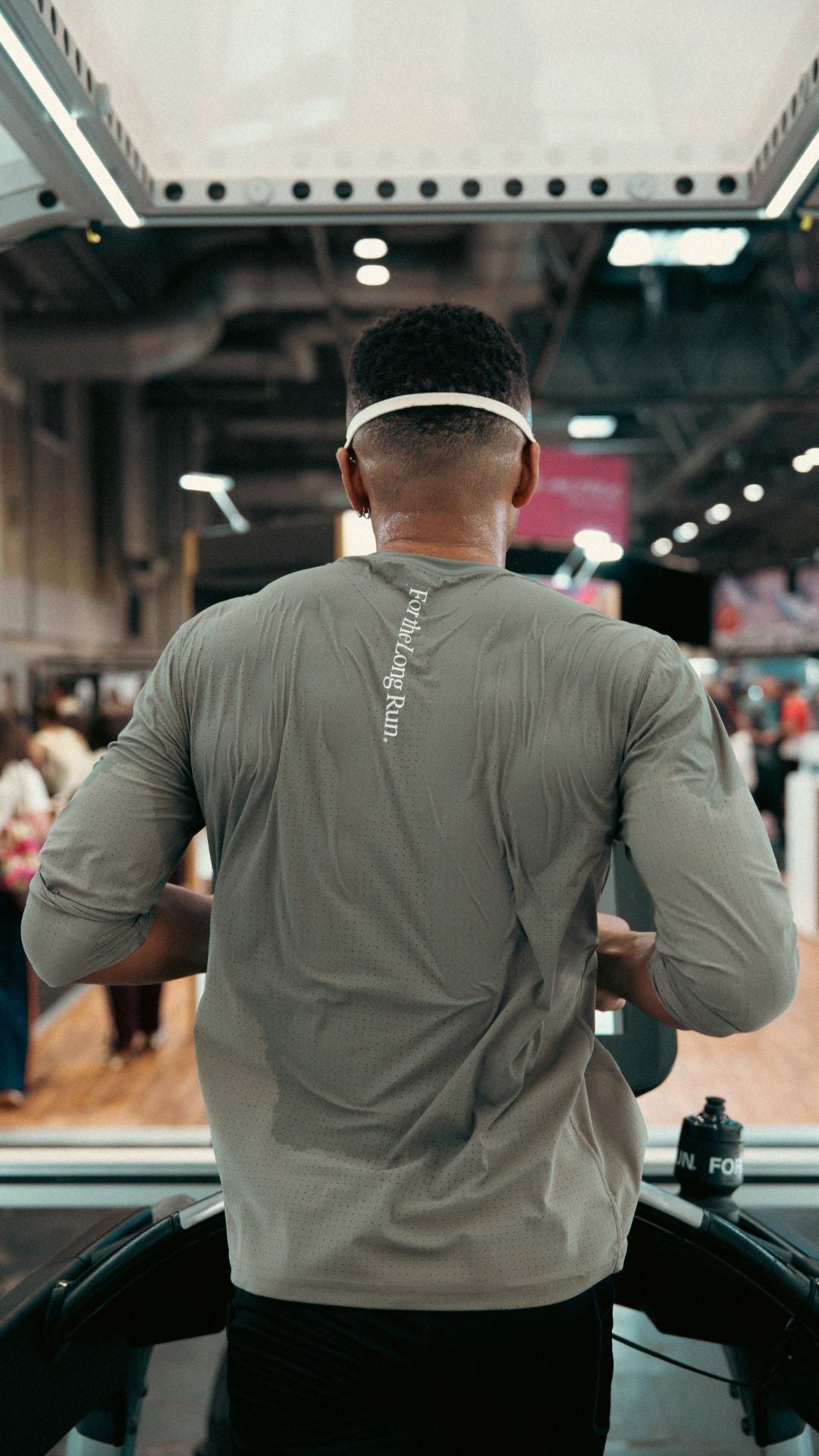 Runner wearing a olive long-sleeve shirt at the National Running Show on a treadmill doing Carbohydrate Oxidation Tests. 