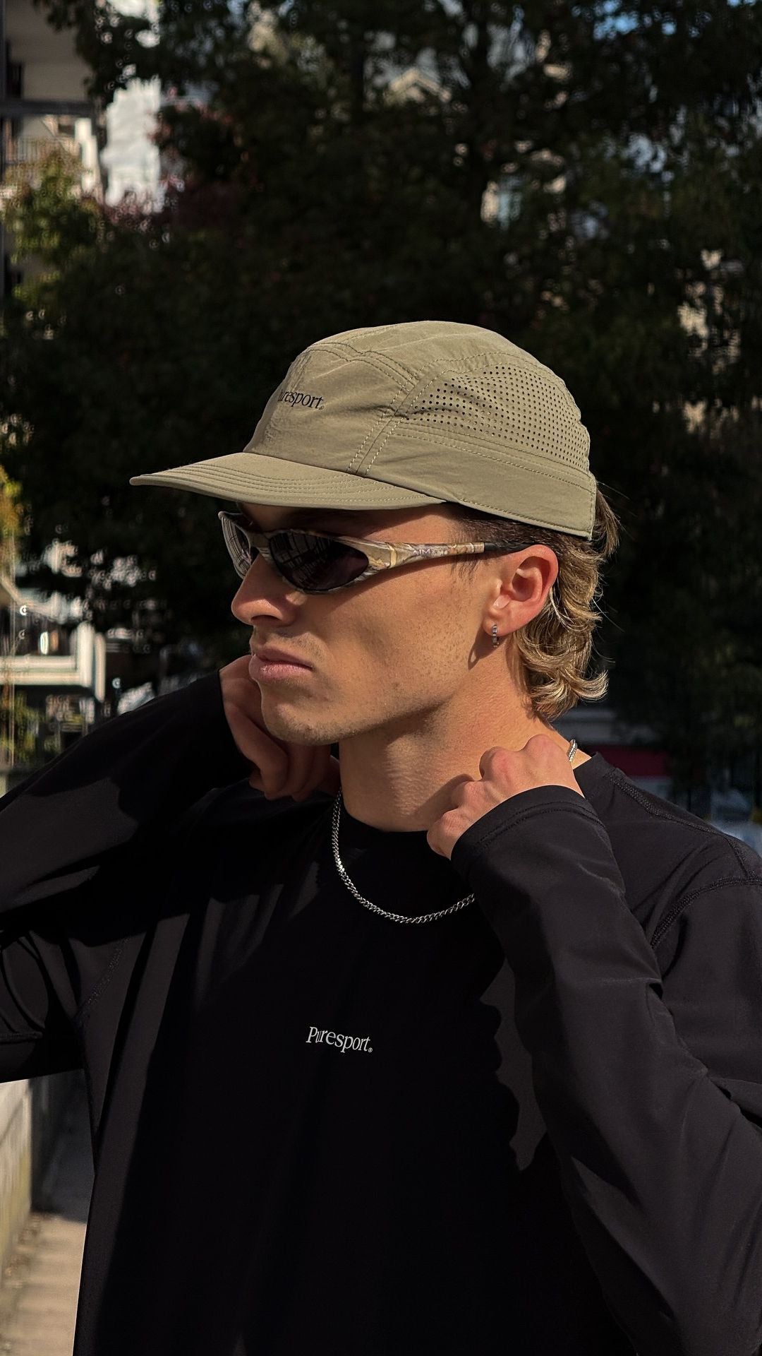 Man wearing a army green cap and AIM sunglasses with a Puresport running top long sleeve. 