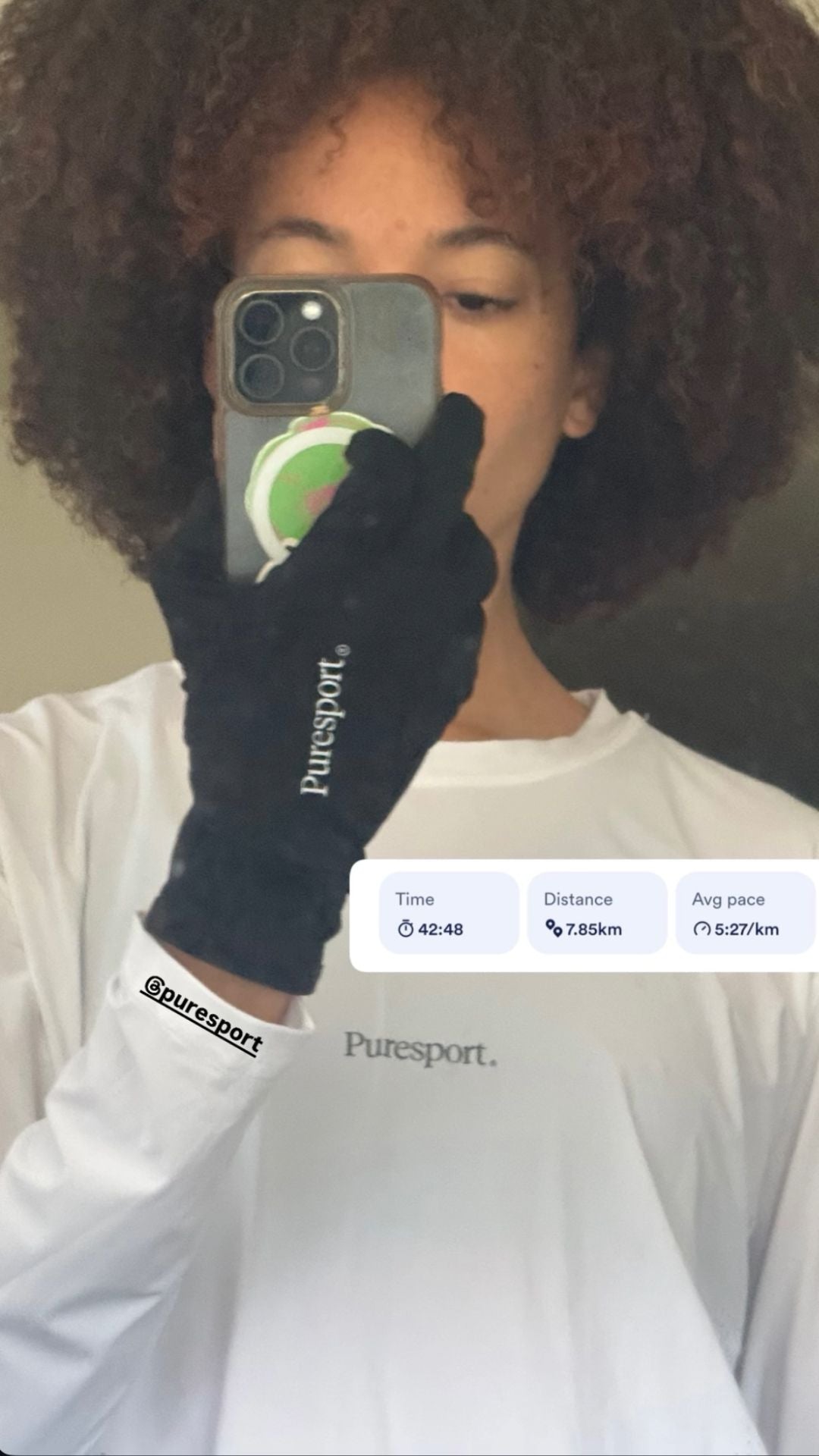 Women wearing a black glove with 'Putesport' branding, holding a phone.