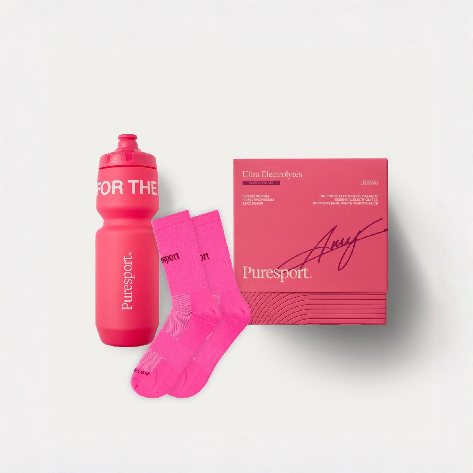 A Puresport hydration bottle in bright pink, a matching pink product box, and a pair of bright pink athletic socks arranged on a clean white background.