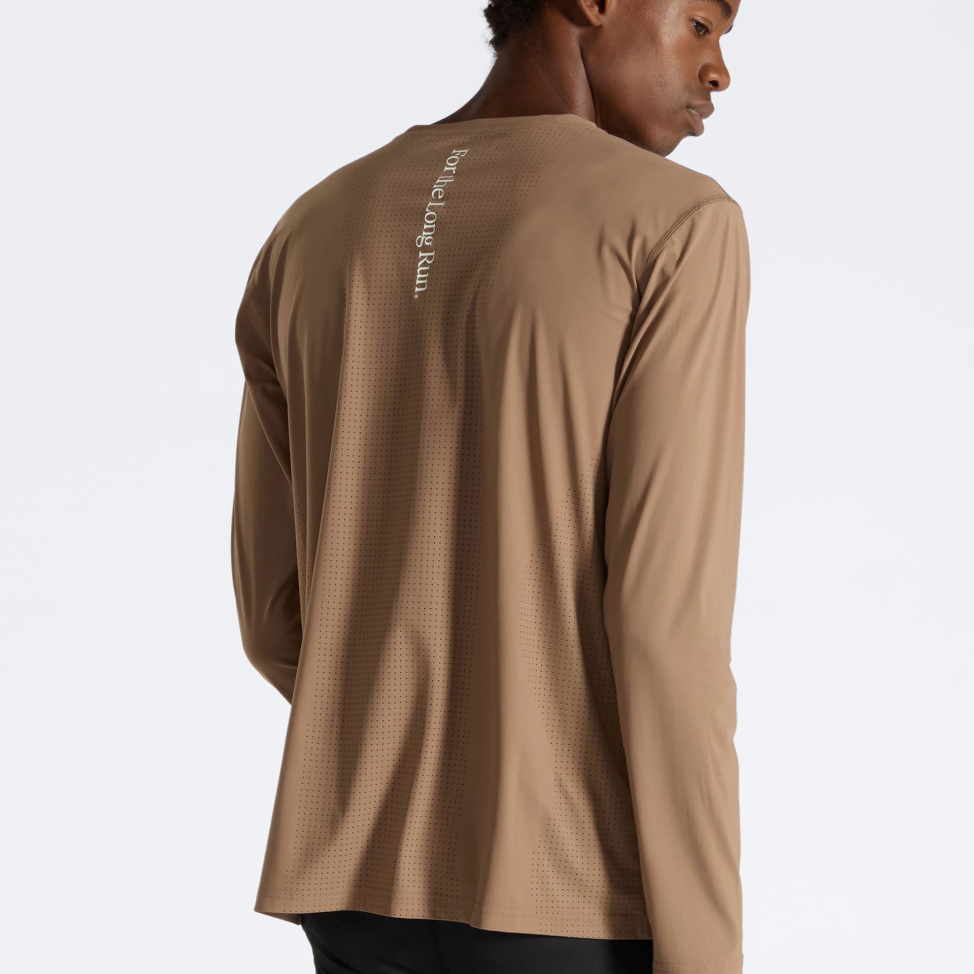 Man wearing a brown running long-sleeve shirt with Puresport logo on the back against a white background