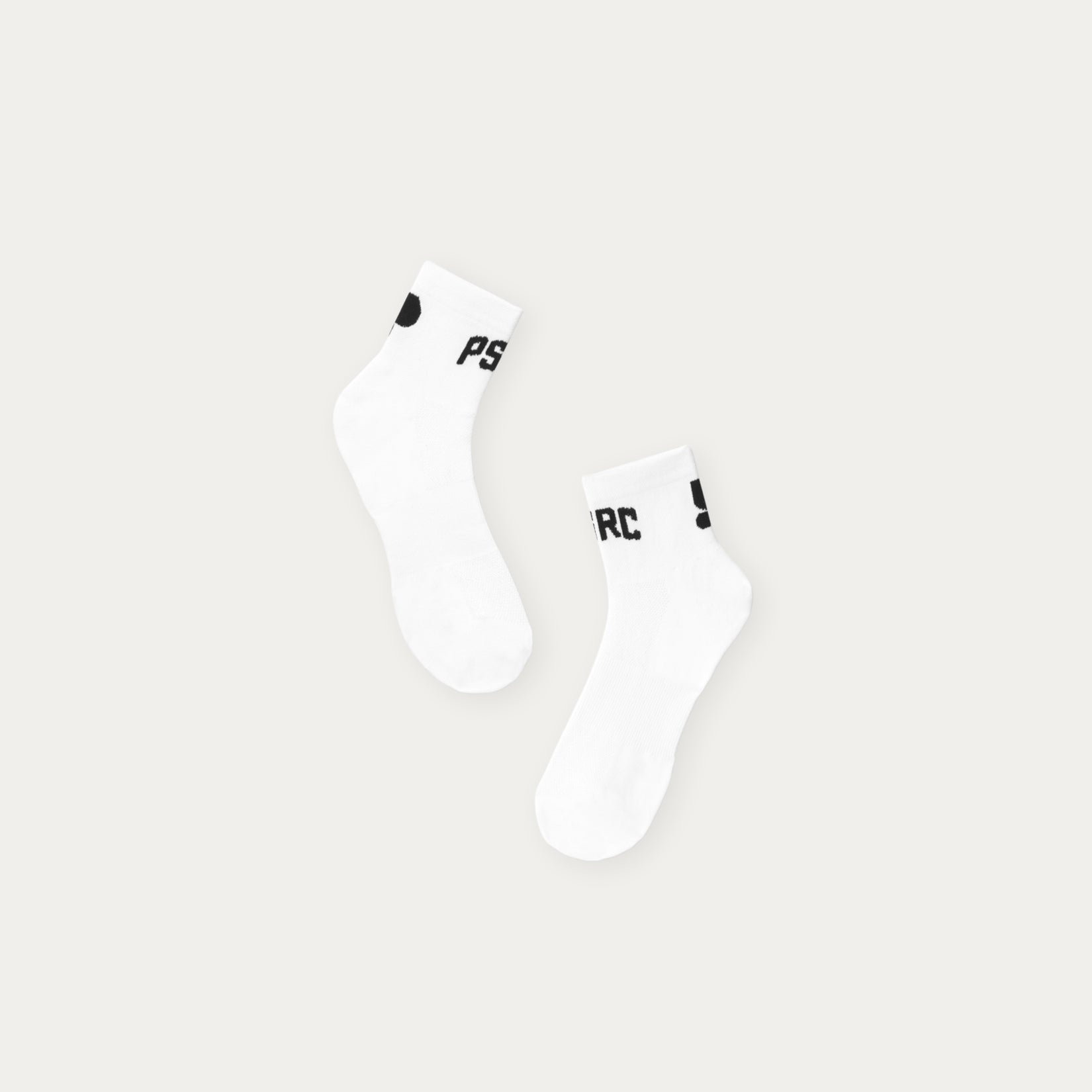 Two white socks with black Puresport logo on a light gray background