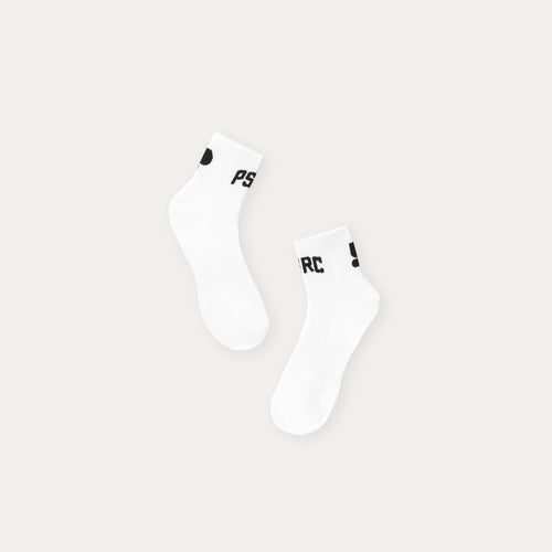 Two white socks with black Puresport logo on a light gray background