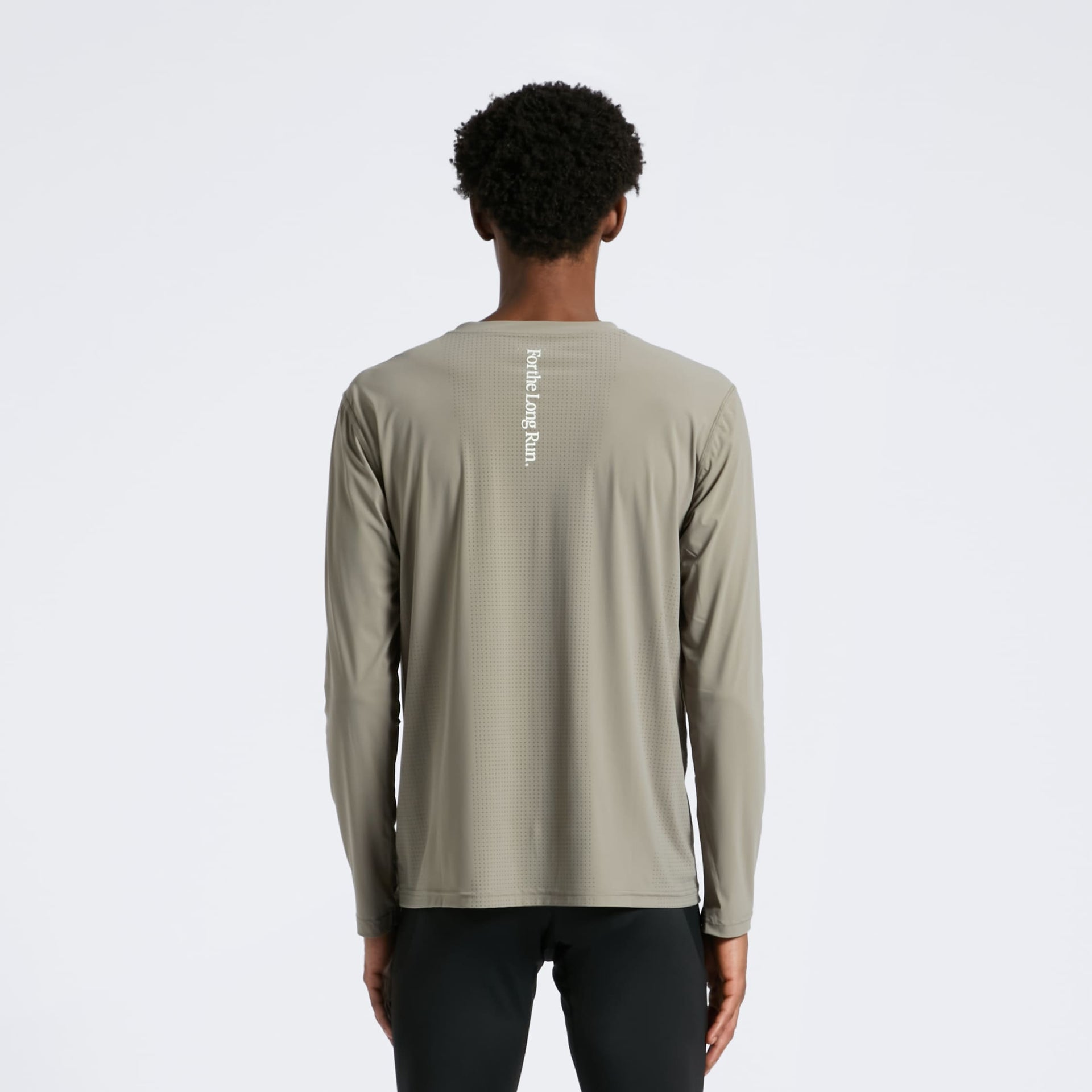 Person wearing a olive long-sleeve shirt with For the Long Run text on the back against a white background