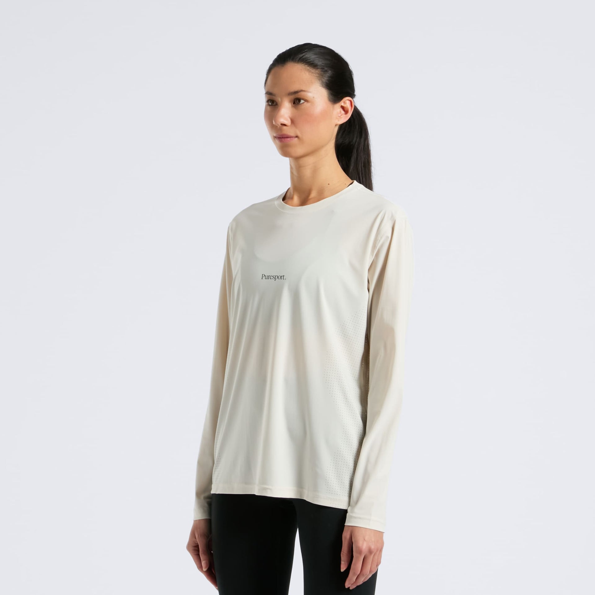 Women wearing a sand long-sleeve run tee with a Puresport logo on a white background