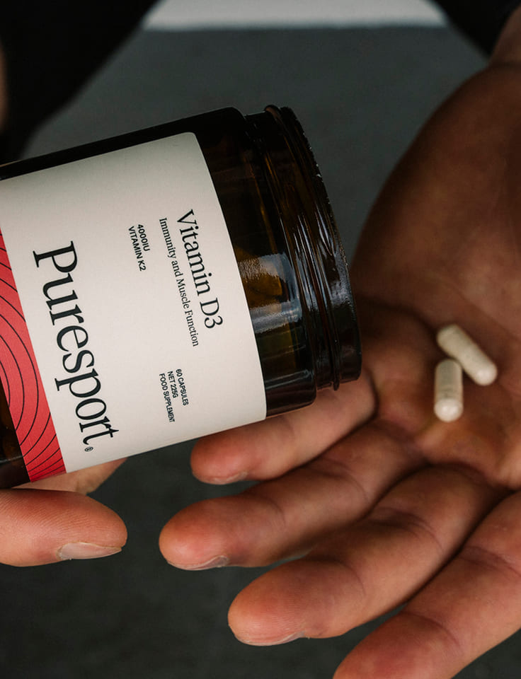 A person holding Vitamin D3 supplements in their hands 