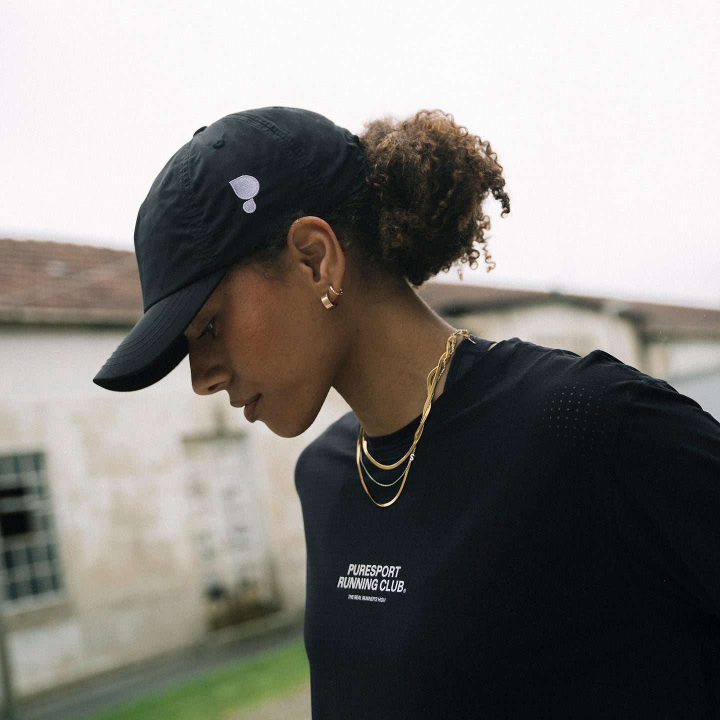 A women wearing Puresport running club hat and long sleeve performance top. 