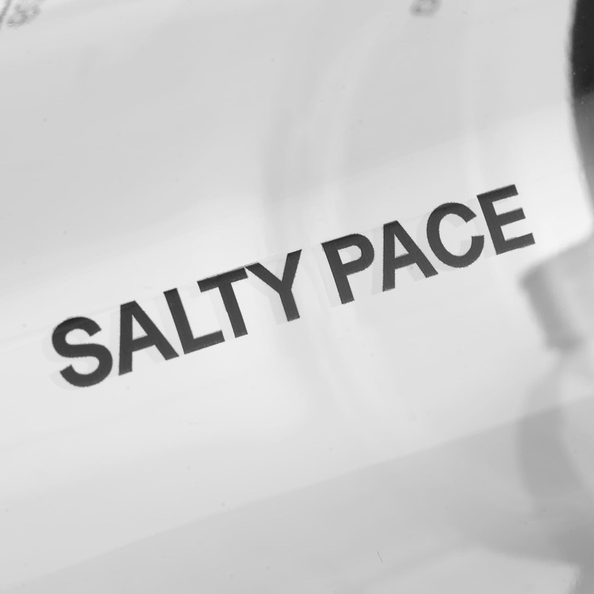 Text 'SALTY PACE' printed on a clear bottle