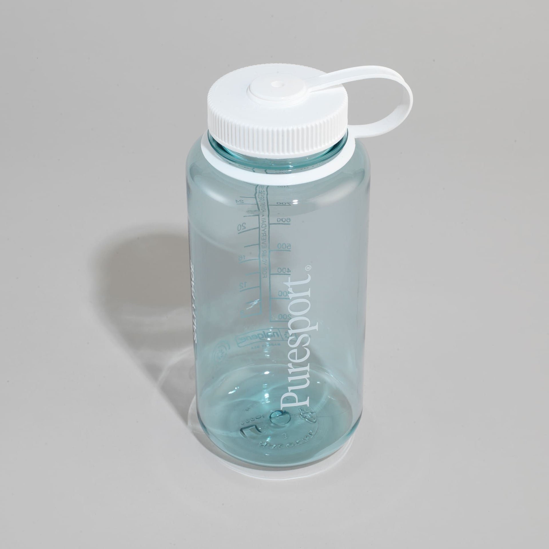 Clear water bottle by puresport with white cap on a gray background