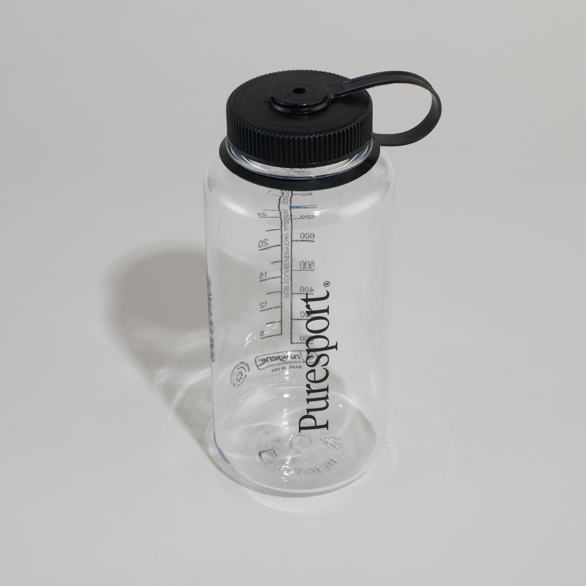 Clear water bottle with black cap and 'Puresport' branding on a light gray background