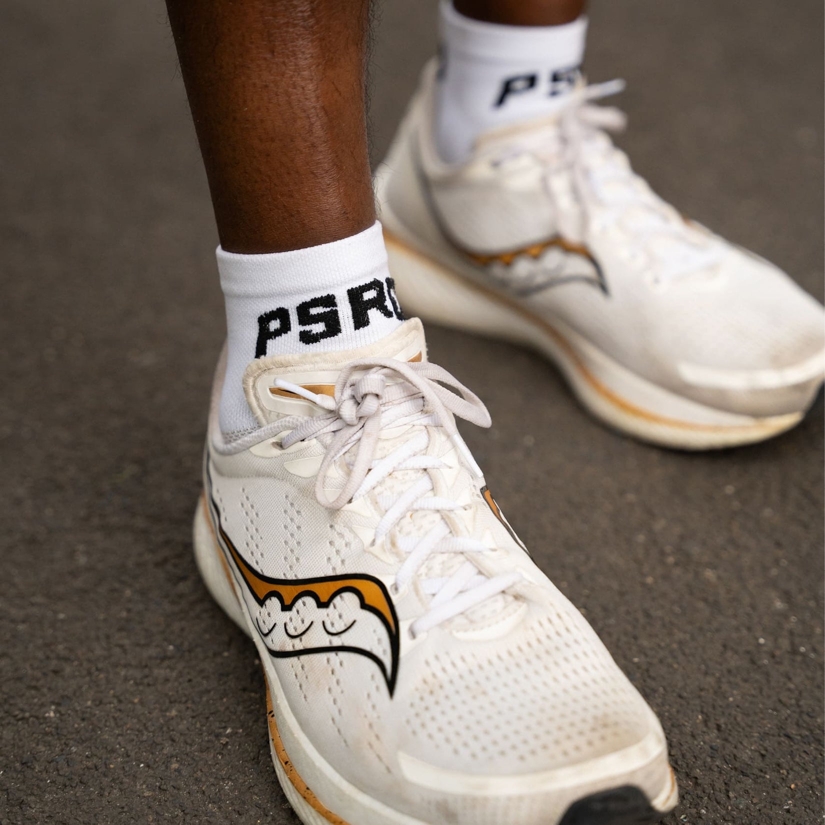 White sneakers with a Puresport running socks and text on a dark surface