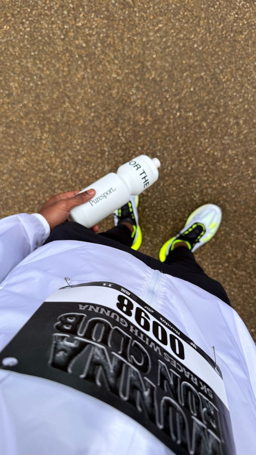 Person holding a white sports water bottle by Puresport before Gunna 5km 