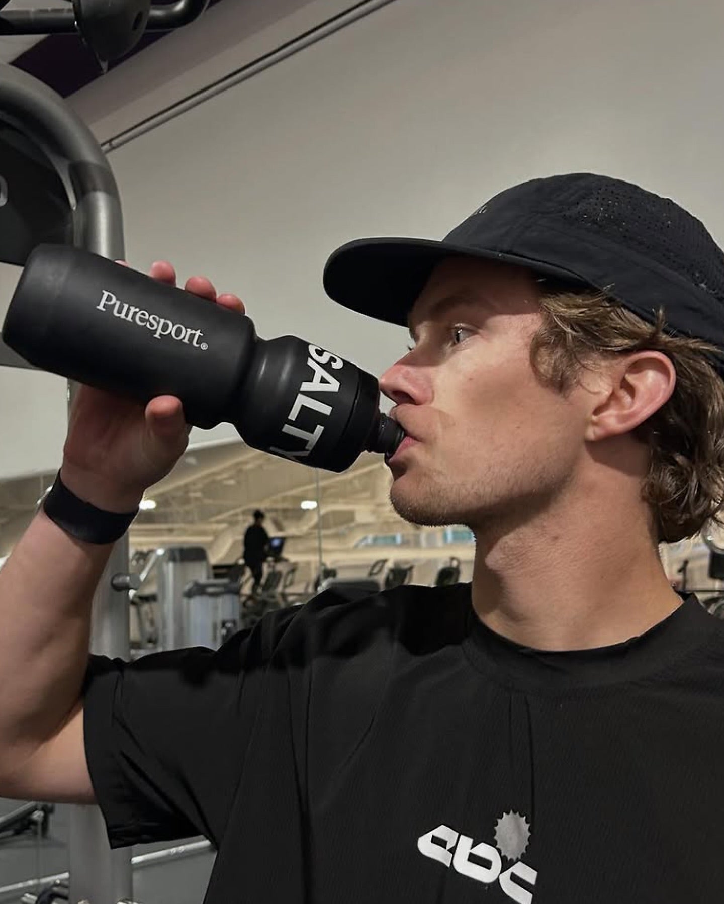 Athlete drinking from a Puresport bottle at the gym